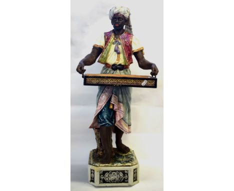 Large late 19th Century Continental pottery figure, modelled as a Moor, in Majolica glazes, holding a large serving tray, the
