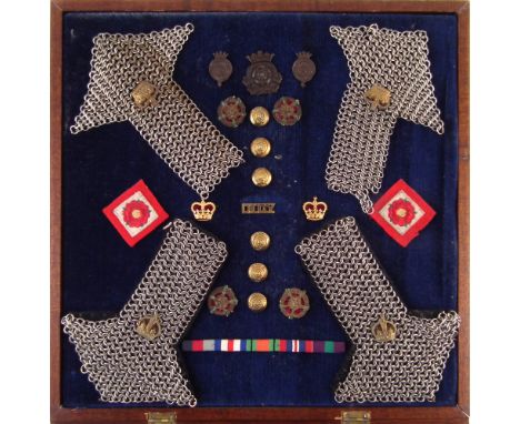 Cased display containing Duke of Lancaster's cap badges , four chain epaulette, D.L.O.Y. badge, various buttons and sew on ba