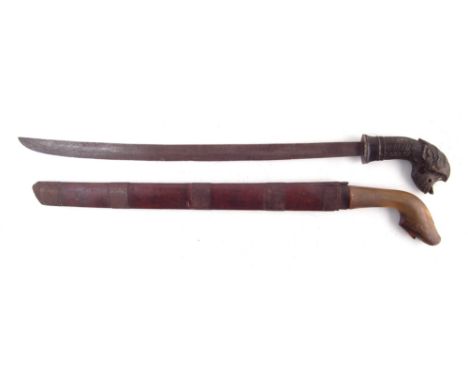 Two Malay /Indonisian Klewang swords, one with horn grip, the other with carved Dog horn grip and hardwood scabbard, (2) 70cm