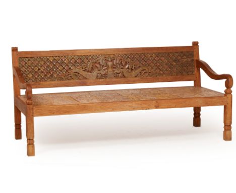 A LARGE CARVED TEAK BENCH
The back rest carved with a central panel of a figure and mythical beasts, within a repeating flora