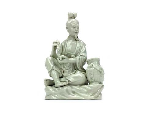 20TH CENTURY CHINESE BLANC DE CHINE FIGURE OF A MAN, modelled seated and holding a pipe, 23.5cm high