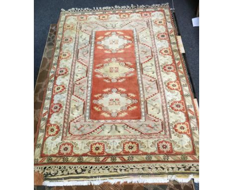 A Turkish hand woven woollen rug, central panel of three diamond lozenge medallions, surrounded by five different borders, ap