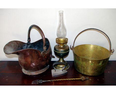 A brass jam pan; a copper helmet shaped coal scuttle; a brass oil lamp; flat iron (4)