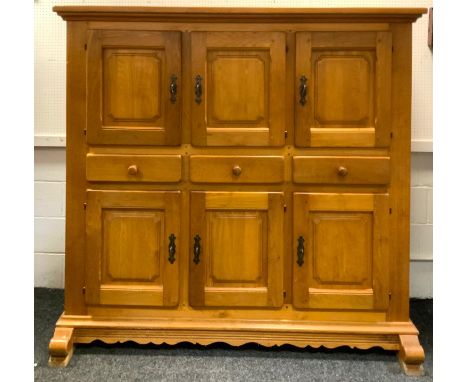 A large country light oak housekeepers cupboard; three fielded panel doors over three drawers, three fielded panel doors to b
