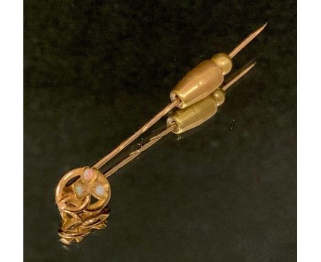 An Edwardian opal and moonstone inset tie pin, yellow metal spiralled pin body, stamped 15ct, 57mm long, 1.6g gross