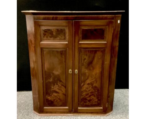 An early 19th century flame Mahogany wall hanging corner cupboard, two paneled doors, shaped triple shelf interior, 104.5cm h