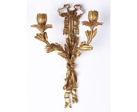 An ormolu twin light wall sconce, 20th c, in Louis XVI style, of leafy scrolling floriform design with ribbon bow wall plate,