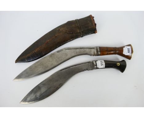 Two vintage Kukri comprising an Indian example with wooden handle, contained in sheath and a horn handled example. [2]. [W]No