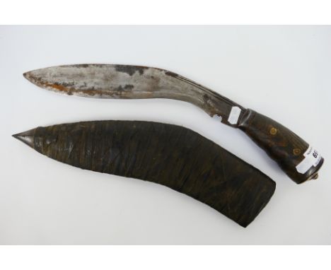 A Gurkha Kukri knife with 30 cm (l) blade, wooden grip and brass bolster, contained in scabbard. [W]