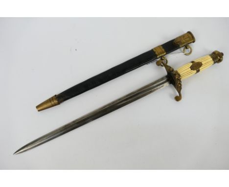 A naval officer's dirk, the ribbed faux ivory handle, with brass mounts and tapered steel blade (36 cm length), in a brass mo