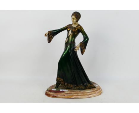 A cold cast Art Deco style figure depicting a stylish young lady, raised on marble base, approximately 48 cm (h). [W]