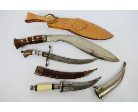 Three knives to include an inlaid bone handled Jambiya in white metal sheath, a wood handled Kukri and similar. [W]Note: This