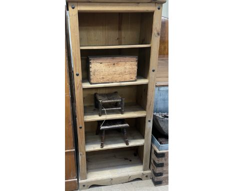 A pine bookcase together with a pine box, stool and a Celtic carved stool
