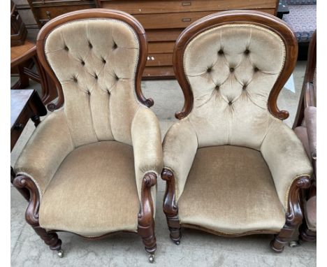 A matched pair of Victorian mahogany framed spoon back chairs, with turned legs and castors, with button back upholstery