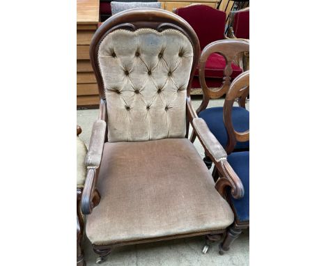 A William IV mahogany framed back library chair, with lotus leaf carved arm terminals on turned legs with castors and button 