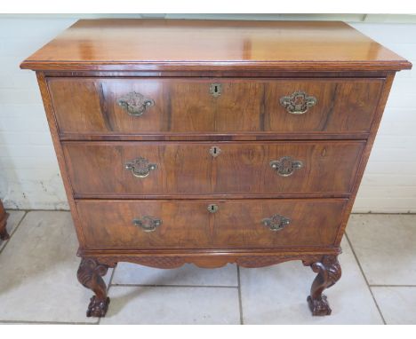 An oak and walnut three drawer chest on cabriole legs and ball and claw feet united by a carved apron in clean restored condi