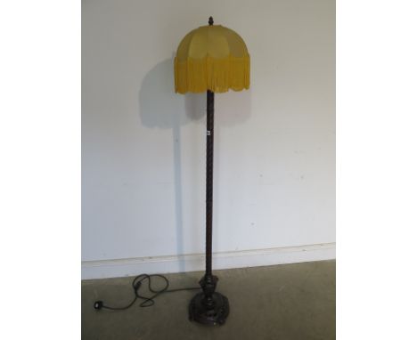 A very unusual 1920s standard lamp and shade, bronzed metal column finishing in a cast iron base mounted on four small feet, 