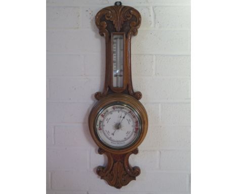 An carved oak case aneroid barometer with 5 inch white ceramic dial, approximately 59cm high, in good clean condition 