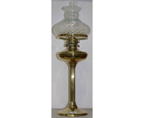 A vintage brass oil lamp on reeded column with dimpled shade and chimney