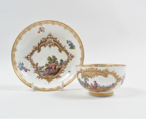 A Meissen tea cup and saucer 18th Century, painted with river and landscape scenes within gilt cartouche