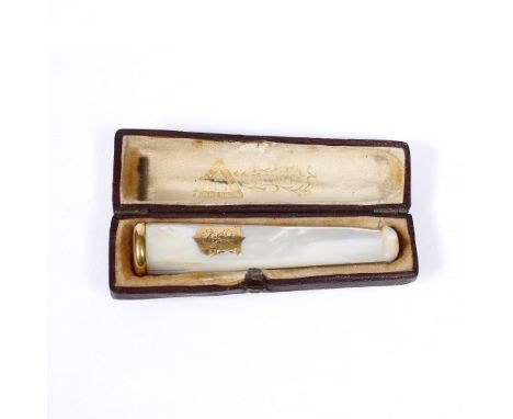 A mother of pearl cigarette holder with yellow metal mount, in original box