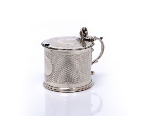 A Victorian silver mustard pot of circular form, with engine turned decoration, shaped thumb piece, blue glass liner, London 