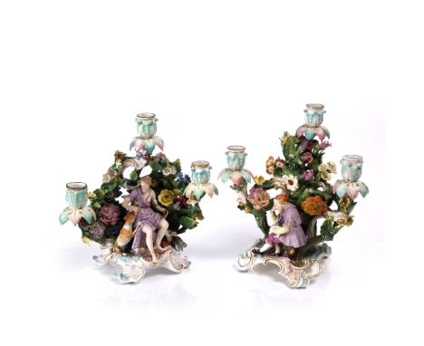 A pair of Meissen porcelain candelabra late 19th Century, each with figures and flowers, blue crossed swords mark, 29cm