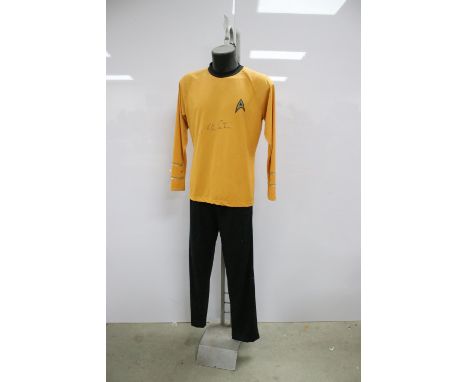 Star Trek - Signed William Shatner - Captain Kirk top outfit with Star Trek emblem in yellow, on stand and measures approx 21