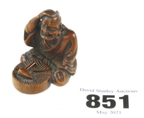 An 18c signed boxwood netsuke of a millwright distraught because he has cracked the millstone he was working on 1 1/2" o/a G+