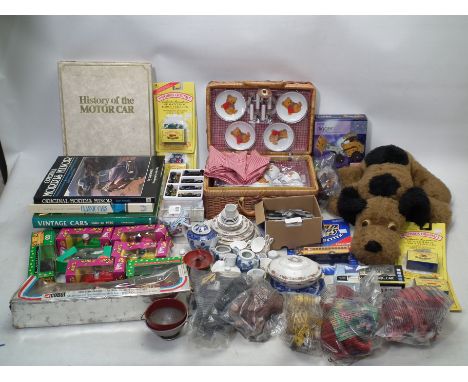 A mixed lot to include a picnic basket tea set, McDonalds toys, A Walt Disney cased baseball, Matchbox and car related books.