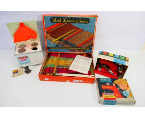 A boxed Vulcan Minor Child's sewing machine, with Sylko thread and a wooden peg doll. A boxed wool weaving loom with a part w