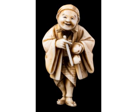 A Japanese carved ivory netsuke of a travelling priest or poet: the smiling man wearing a flowing coat and holding two peache