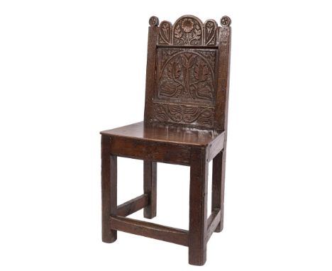 A 17th Century carved oak child's chair: the back with shaped arcaded top rail with flowerhead and foliate decoration and pan