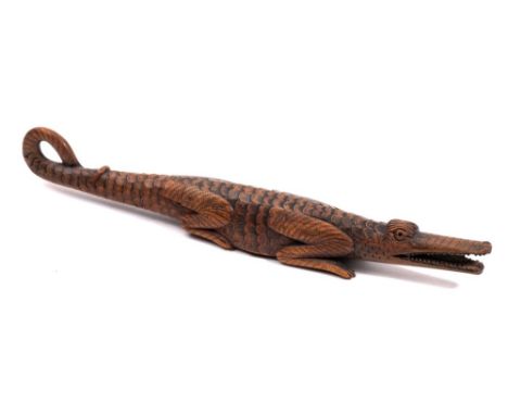 A 19th Century Swiss or Austrian novelty nutcracker: carved as a crocodile with open mouth and curled tail, 31cm. long.*Note 