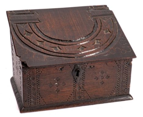 A late 17th Century carved oak box: the sloping hinged lid recycled from an earlier 17th Century chest panel with lunette and