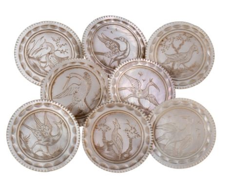 A set of eight large 19th century mother of pearl buttons: engraved with birds in landscapes within line and diaper borders, 