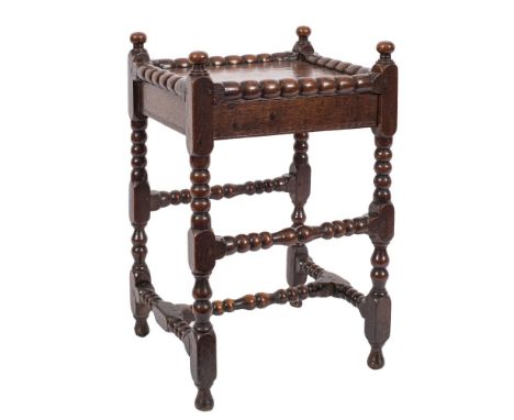 A Charles II oak bobbin turned occasional table: having turned finials fitted with a replaced frieze drawer on bobbin turned 