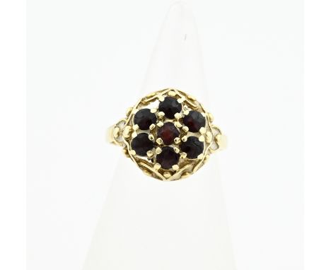 Yellow gold ring, 585/000, with garnet. Ring with an openwork round head set with 7 faceted garnets. ø head 14 mm. ø 53. appr