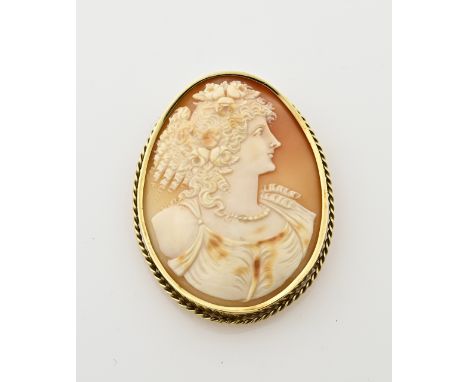 Yellow gold brooch/pendant, 585/000, with cameo. Large brooch/pendant with an oval yellow gold edge with a twisted finish and