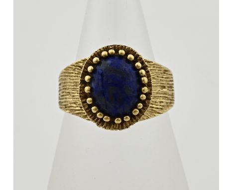 Yellow gold ring, 585/000, with a wide tooled band and an ascending oval bezel with an oval cabouchon cut lapis lazuli. Head 