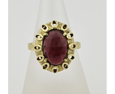 Yellow gold ring, 585/000, with garnet. Ring with a large oval openwork head set with an oval faceted garnet, with a purple g