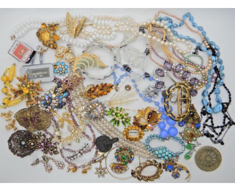 A bag full of vintage costume jewellery to include, a Dunlop promotional handbag mirror, enamelled buckle, lion clock clasp e