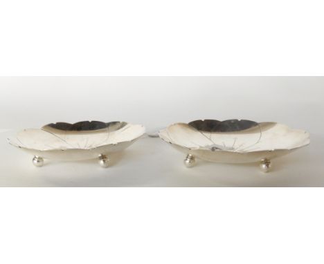 A pair of silver dishes by Roberts &amp; Belk, Sheffield 1946, in the form of lily pads on four ball feet, 10.7cm diameter, 1