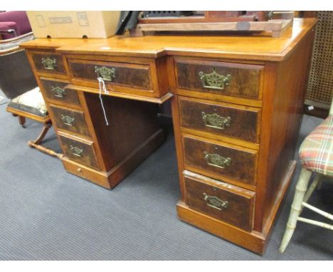 A late Victorian walnut breakfront kneehole desk with brass handles on a plinth base, 78 x 122 x 51cm  