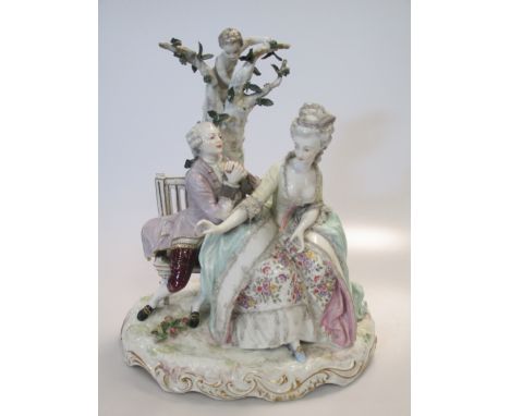 A German porcelain figural group depicting a courting couple seated on a bench, on a gilt scrolled base, 31cm high  