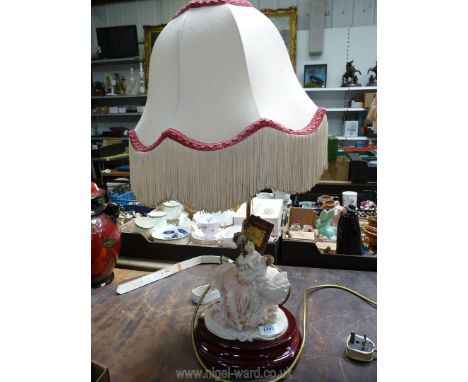 A continental porcelain table Lamp in the form of a mother and child, with fringed lamp shade, 26'' high.