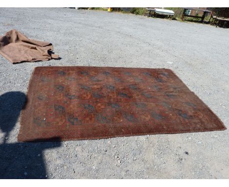 A red/rust ground bordered, patterned Carpet, 116" x 78".