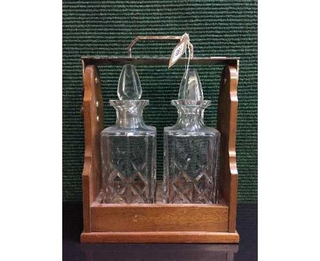 A mahogany two decanter tantalus with silver plated handed with key 