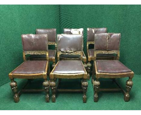A set of six carved oak dining chairs upholstered in button leather 