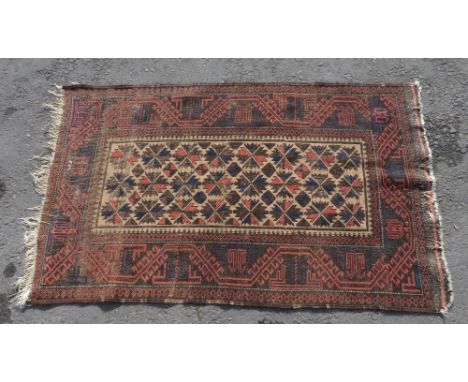 An early 20th century Turkestan belouch rug, the central field with foliate type medallions with guard stripes and wide borde